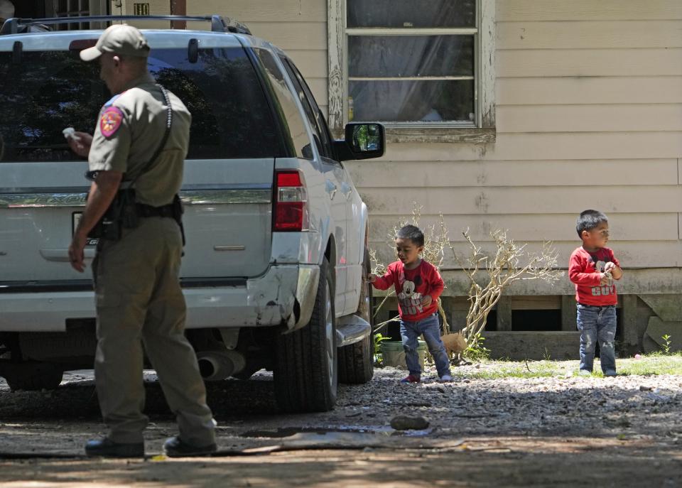 Josue, left, and Nathan Barcenas play outside their home as law enforcement continues to investigate the neighborhood Sunday, April 30, 2023, where a mass shooting occurred Friday night, in Cleveland, Texas. The search for a Texas man who allegedly shot his neighbors after they asked him to stop firing off rounds in his yard stretched into a second day Sunday, with authorities saying the man could be anywhere by now. Francisco Oropeza, 38, fled after the shooting Friday night that left five people dead, including a young boy. (AP Photo/David J. Phillip)