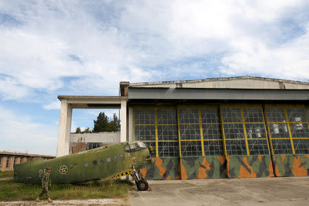 An Albanian Air Force member walks near an old non-function Airplane (Antonov An-2 ) in Kucova Air Base in Kucova, Albania, October 3, 2018. REUTERS/Florion Goga