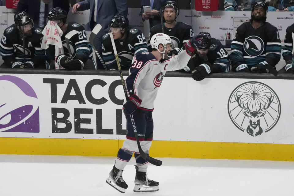 Columbus Blue Jackets center Boone Jenner (38) celebrates in front of the San Jose Sharks bench after his goal during the third period of an NHL hockey game in San Jose, Calif., Saturday, Feb. 17, 2024. (AP Photo/Jeff Chiu)