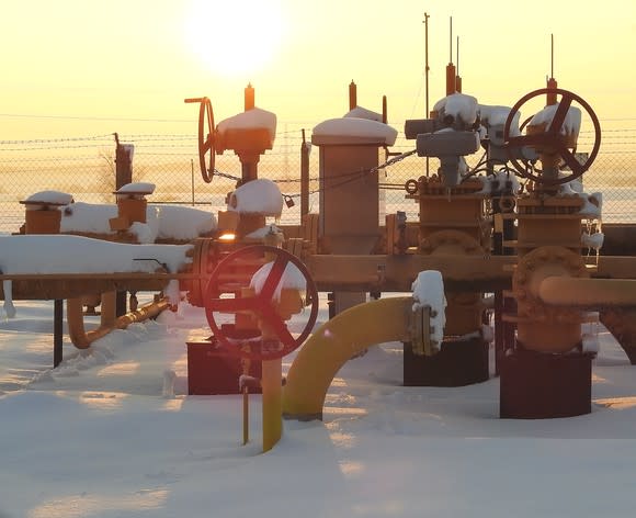 A natural gas field during winter at sunset.