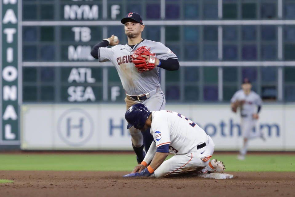 Cleveland Guardians second baseman Andres Gimenez, left, throws to first base on an attempted double play after making the out on Houston Astros’ <a class="link " href="https://sports.yahoo.com/mlb/players/11768/" data-i13n="sec:content-canvas;subsec:anchor_text;elm:context_link" data-ylk="slk:Jeremy Pena;sec:content-canvas;subsec:anchor_text;elm:context_link;itc:0">Jeremy Pena</a>, right, during the ninth inning of a baseball game Wednesday, May 1, 2024, in Houston. (AP Photo/Michael Wyke)