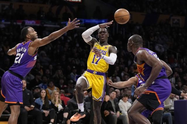 Lakers guard Dennis Schroder passes the ball between Phoenix Suns forward T.J. Warren, left, and center Bismack Biyombo