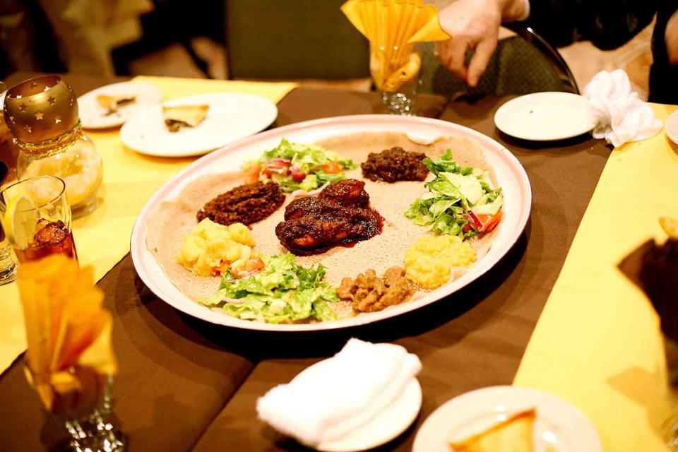 Yedora Watt, Yemisir Watt, Kik Alitcha and Ethiopian Potato Salad are served over Injera with salad at Queen of Sheba Restaurant in Oklahoma City.