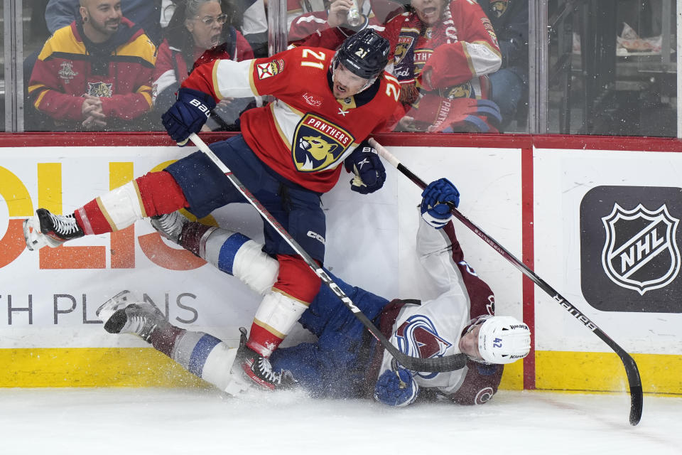 Florida Panthers center Nick Cousins (21) slams Colorado Avalanche defenseman Josh Manson (42) into the boards during the second period of an NHL hockey game, Saturday, Feb. 10, 2024, in Sunrise, Fla. (AP Photo/Wilfredo Lee)