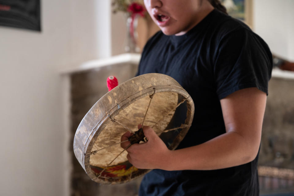 <em>Ashton Tendoy, Jennifer’s son, plays a traditional drum song for his mother. (Photo/Ava Rosvold for BYLINE magazine)</em>