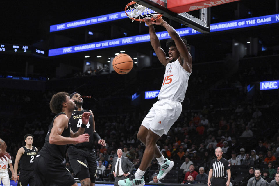 Miami forward Norchad Omier dunks the ball as Colorado guard J'Vonne Hadley (1) and Colorado center Eddie Lampkin Jr. trail during the first half of an NCAA college basketball game in the NABC Brooklyn Showcase, Sunday, Dec. 10, 2023, in New York. (AP Photo/John Jones)