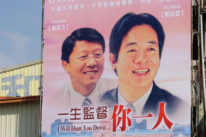 台南市議員謝龍介把網友所創作的KUSO版電影海報製作成大型看板，高掛在自己的服務處。（盧逸峰攝）