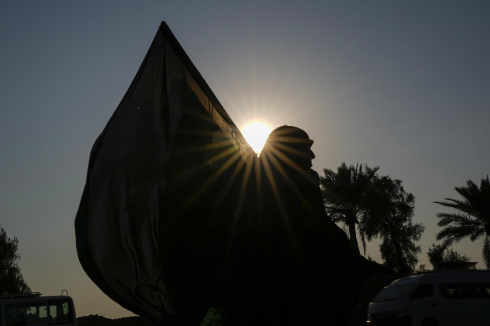 Shiite pilgrims make their way to the shrine of Imam Moussa al-Kadhim, a key Shiite saint, who died at the end of the eighth century, for the annual commemoration of his death in Baghdad, Iraq, Wednesday, Feb. 15, 2023. (AP Photo/Hadi Mizban)