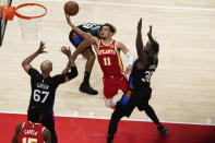 Atlanta Hawks' Trae Young (11) shoots against New York Knicks' Julius Randle (30) and Taj Gibson (67) during the first half in Game 3 of an NBA basketball first-round playoff series Friday, May 28, 2021, in Atlanta. (AP Photo/Brynn Anderson)