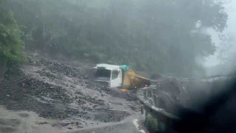 受颱風卡努影響，南投縣仁愛鄉4日雨勢不斷，「投89線」力行產業道路有貨車遭土石流掩埋，土石覆蓋半個車身，幸駕駛及時逃出。（翻攝畫面／中央社）