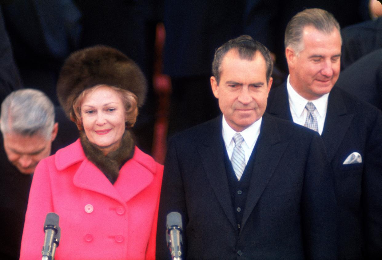 Pat Nixon stands with husband Richard Nixon during his 1969 inauguration. To the right of the couple is Nixon's vice president, Spiro Agnew. After their ticket won a second term in 1972, both men resigned their offices in disgrace.