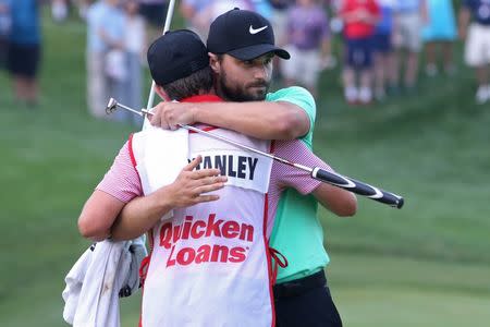 Jul 2, 2017; Potomac, MD, USA; Kyle Stanley hugs his caddie Bryan Reed after making a par putt on the first playoff hole to win the Quicken Loans National golf tournament at TPC Potomac at Avenel Farm. Mandatory Credit: Geoff Burke-USA TODAY Sports