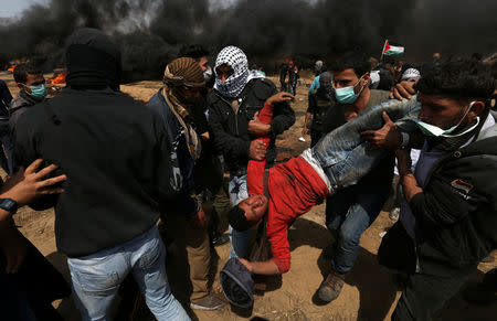 A wounded demonstrator is evacuated during clashes with Israeli troops at a protest at the Israel-Gaza border, April 27, 2018. REUTERS/Ibraheem Abu Mustafa