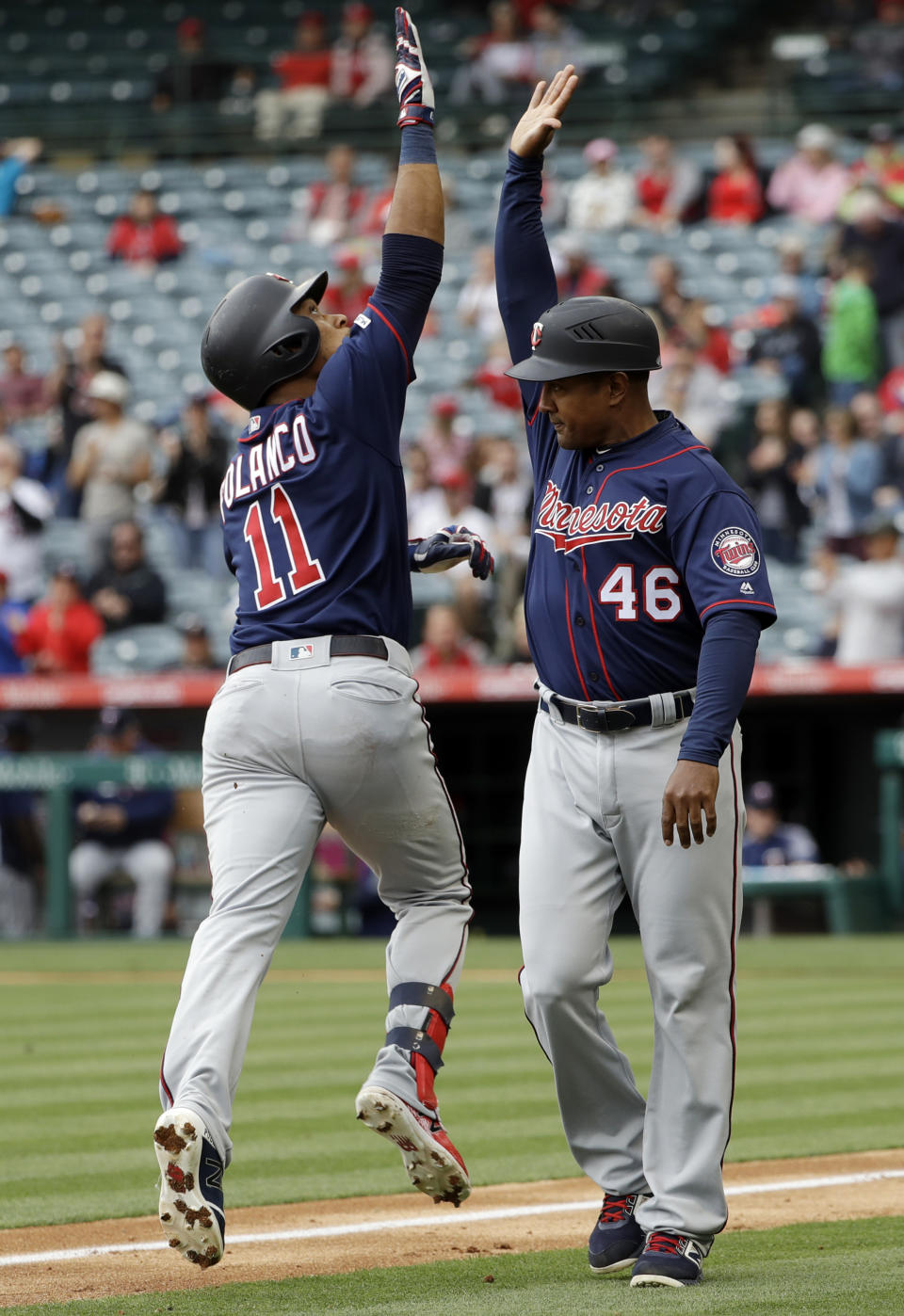 Minnesota Twins' Jorge Polanco (11) celebrates his two-run home run with third base coach Tony Diaz (46) during the second inning of a baseball game against the Los Angeles Angels Thursday, May 23, 2019, in Anaheim, Calif. (AP Photo/Marcio Jose Sanchez)