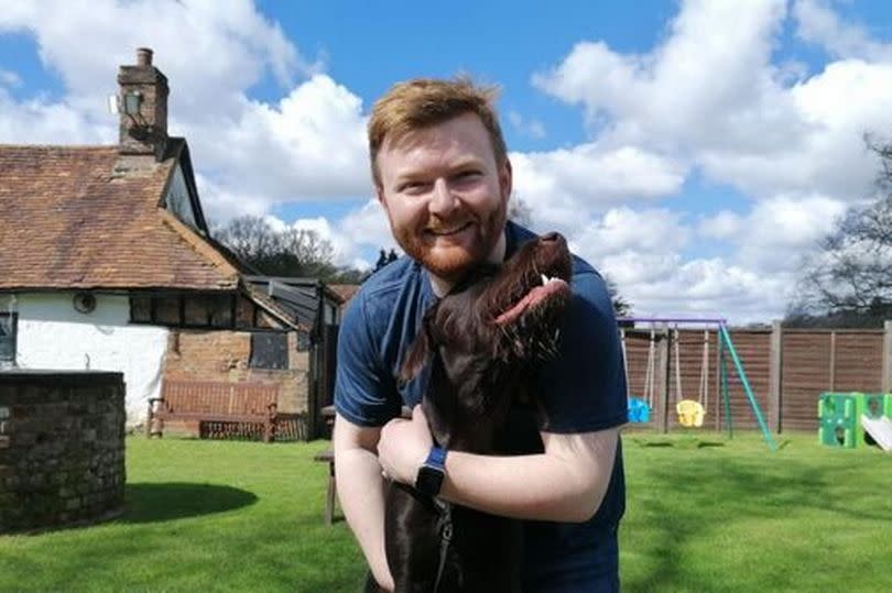 Jack Drury holding his dog Dexter outside the village pub