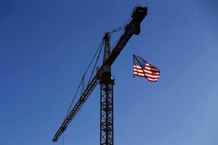 A crane flies an American flag over a construction site in downtown Los Angeles