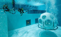 Belgians Florence Lutje Spelberg and Nicolas Mouchart dive next to "The Pearl", a spheric dining room placed 5 metres underwater in the NEMO33 diving center, one of the world's deepest pools (33 metre/36 yards) built to train professional divers, before enjoying a meal inside, in Brussels, Belgium January 30, 2017. Picture taken January 30, 2017 REUTERS/Yves Herman