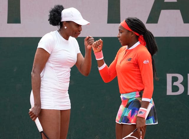 Doubles partners Venus Williams and Coco Gauff bump fists during their first-round loss