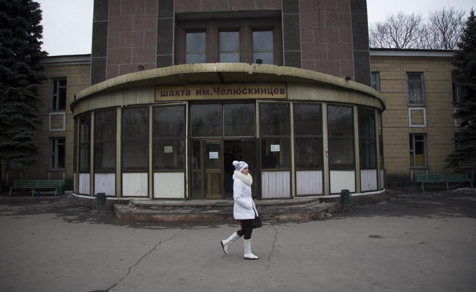 In this photo taken Tuesday, Feb. 25, 2014, a woman walks past the entrance of a coal mine in the outskirts of Donetsk, eastern Ukraine. If Ukraine looks neatly delineated on maps, its history is a tangle of invasions and occupations and peoples and religions, a place of ill-defined borders that for centuries has been struggling to define itself. The modern nation is so sharply divided by culture and loyalty, split between allegiance to Moscow and allegiance to Western Europe, that it often can appear ready to simply snap in two. (AP Photo/Darko Bandic)