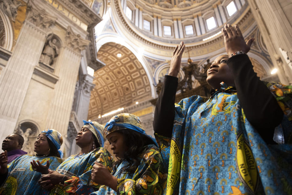 A woman prays during a Mass celebrated by Pope Francis for the Congolese community of Rome, in St. Peter's Basilica at the Vatican Sunday, Dec. 1, 2019. (AP Photo/Alessandra Tarantino)