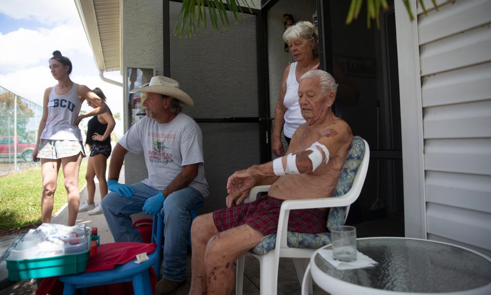 Members of the United Cajun Navy treat injuries to Egon Schulz, 83. a winter resident of the Island Park neighborhood in South Fort Myers, on Wednesday, Oct. 5, 2022. He fallen down stairs in the dark after Hurricane Ian arrived. On the right is his wife, Brigitte Schulz.