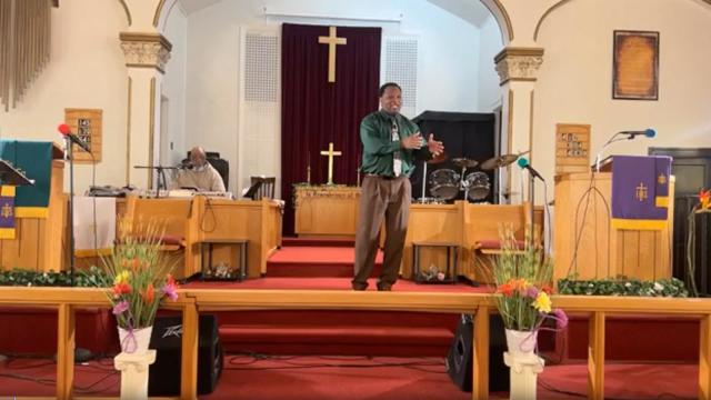 A man points a gun at a church pastor before getting tackled.