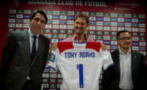 Former Arsenal and England captain Tony Adams (C) holds Granada's jersey as he is flanked by the club's vice-president Kangning Wang (R) and the club's board member Ignacio Cuerva, after being presented as the new head coach in Granada, Spain April 11, 2017. REUTERS/Pepe Marin