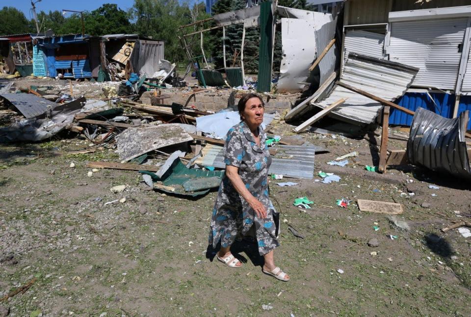 A woman walks past destroyed structures at a local market in Donetsk (REUTERS)
