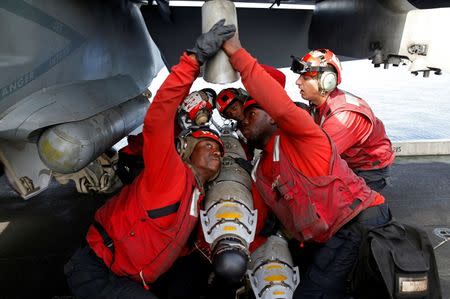 US Navy sailors attach ammunition to a F/A-18 fighter jet before a mission on the flight deck of the USS Harry S. Truman aircraft carrier in the eastern Mediterranean Sea June 14, 2016. REUTERS/Baz Ratner