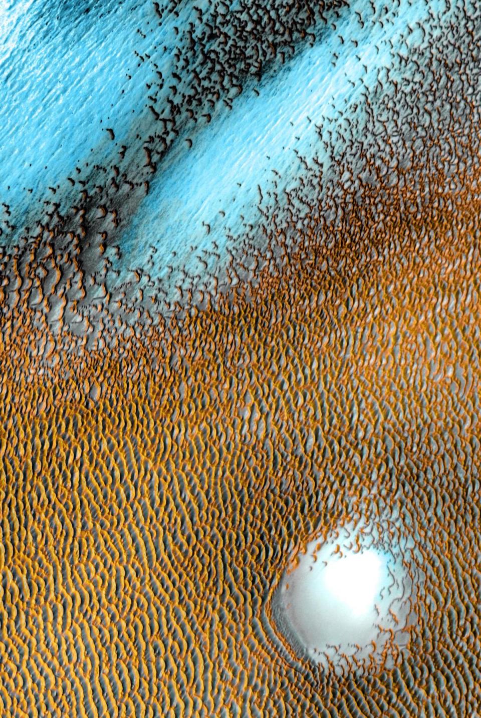 A composite image of Mars from NASA showing the planet's polar cap sand dunes, with different colors to highlight surface temperatures