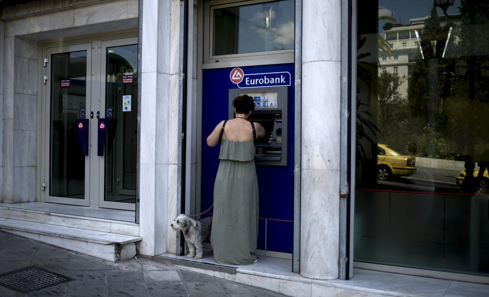 A woman uses a Eurobank ATM in Athens, Greece, August 19, 2015. German lawmakers overwhelmingly voted in favour of a third Greek bailout on Wednesday, heeding a call from Finance Minister Wolfgang Schaeuble to give Greece the chance for a new start, despite his own concerns it might not work. REUTERS/Stoyan Nenov