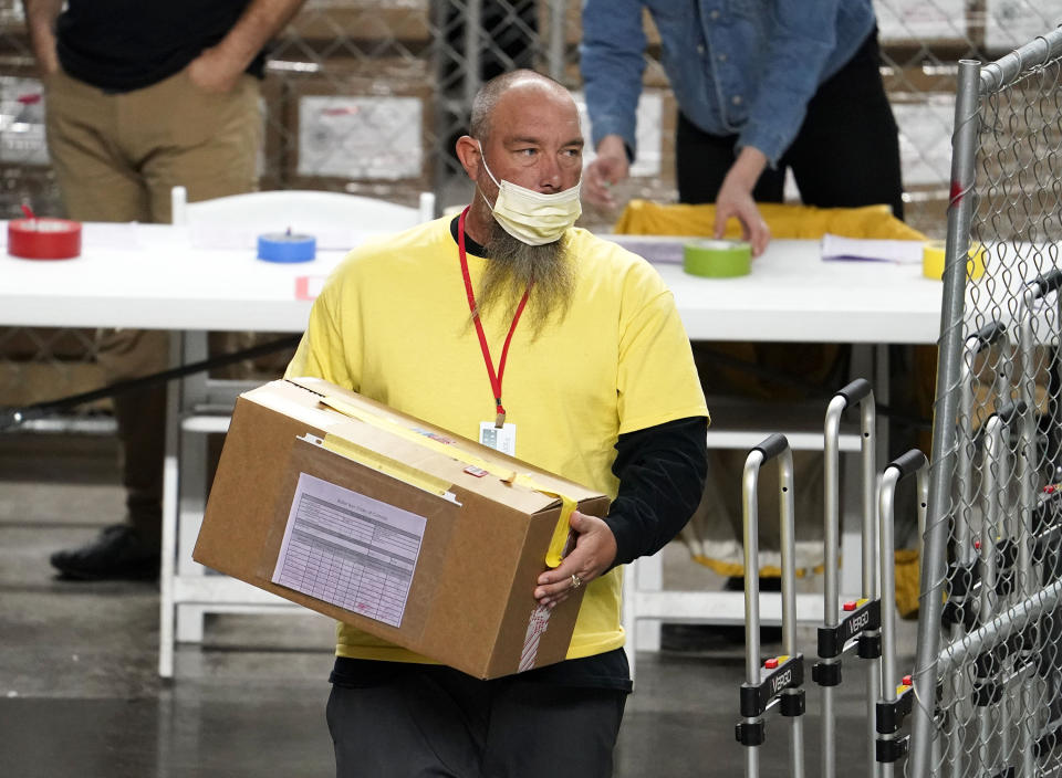 A box of Maricopa County ballots cast in the 2020 general election are delivered to be examined and recounted by contractors working for Florida-based company, Cyber Ninjas, who was hired by the Arizona State Senate at Veterans Memorial Coliseum in Phoenix, Thursday, April 29, 2021. (Rob Schumacher/The Arizona Republic via AP, Pool)