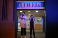 FILE - In this March 16, 2020, file photo, Health workers react as people applaud from their houses in support of the medical staff that are working in COVID-19 outbreak in Barcelona, Spain. At a time of unfathomable isolation, people in many European cities hit hard by the new coronavirus are taking at least a minute to come together in gratitude as they stand at open windows or on balconies singing, cheering and applauding. (AP Photo/Joan Mateu)