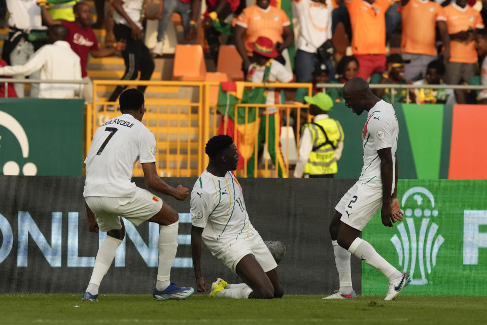 Guinea's Mohamed Bayo, center, celebrates with teammates Morgan Guilavogui, left, and Antoine Conte after scoring the opening goal during the African Cup of Nations Group C soccer match between Cameroon and Guinea at the Charles Konan Banny stadium in Yamoussoukro, Ivory Coast, Monday, Jan. 15, 2024. (AP Photo/Sunday Alamba)