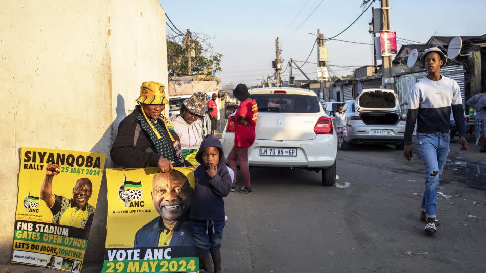 Workers for political parties including the African National Congress (ANC) and Economic Freedom Fighters (EFF) stand next to a voting station on May 27 in Alexandra Township, South Africa. - Per-Anders Pettersson/Getty Images