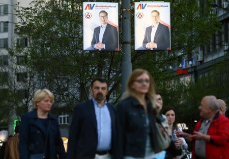 People walk past posters of Serbian Prime Minister and presidential candidate Aleksandar Vucic in Belgrade, Serbia, March 31, 2017. REUTERS/Antonio Bronic