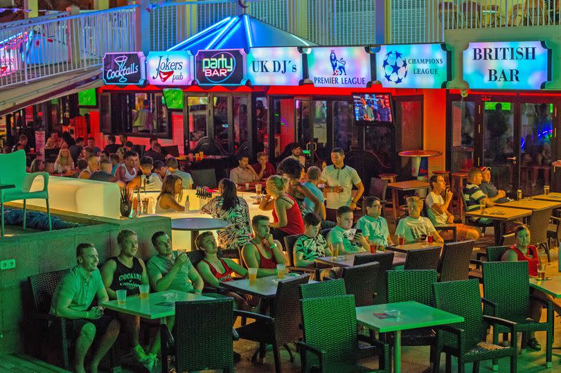 Tourists are seen enjoying the atmosphere of a local bar on Punta Ballena Street.