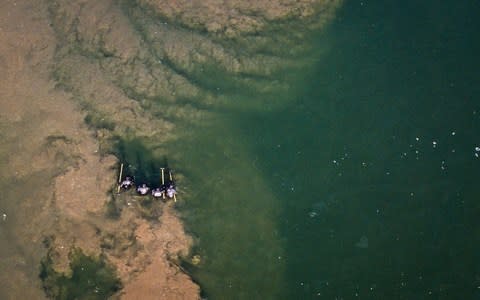 An aerial shot of police officers wading through a pond in search of Libby Squire - Credit: SWNS