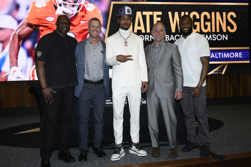 Baltimore Ravens first-round draft pick Nate Wiggins, center, poses with assistant head coach/pass game coordinator Chris Hewitt, left, coach John Harbuagh, second from left, executive vice president and general manager Eric DeCosta, second from right, and defensive coordinator Zachary Orr, right, at an NFL football news conference, Friday, April 26, 2024, in Owings Mills, Md. (AP Photo/Nick Wass)