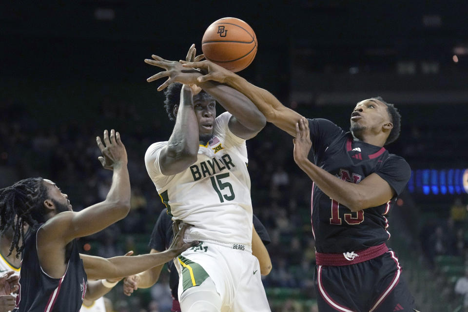 Baylor forward Josh Ojianwuna (15) reaches for the rebound against Nicholls State guard Byron Ireland and forward Jamal West Jr. during the first half of an NCAA college basketball game in Waco, Texas, Tuesday, Nov. 28, 2023. (AP Photo/LM Otero)