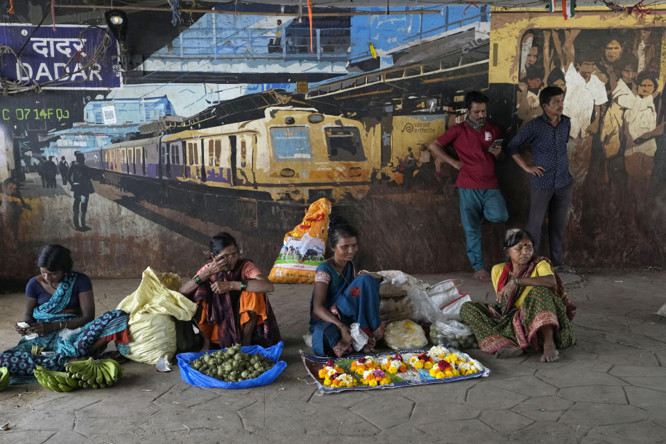 Indian women vendors await customers outside a train station on International Women's Day in Mumbai, India, Friday, March 8, 2024. (AP Photo/Rajanish Kakade)