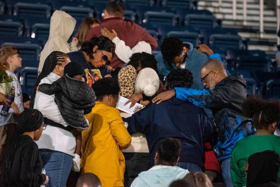 Family, friends and community members pray together after a candlelight vigil in honor of three Gautier High School graduates at Gautier High School in Gautier on Thursday, Dec. 7, 2023. Se’Dhari Saniya Watson-Person, Kyla “Muffin” Watkins, and Tatyanna Richmond were involved in a fatal crash on Tuesday, leading to the deaths of Watson-Person and Watkins. Richmond remains hospitalized.