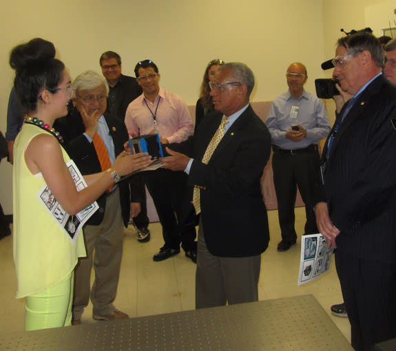 Sarah Hovsepian, manager of the SpaceShop fabrication lab at NASA's Ames Research Center, gives NASA chief Charles Bolden a ceremonial cubesat during his tour of Ames on May 24, 2013. To the left of Bolden is Congressman Mike Honda (D-Calif.);