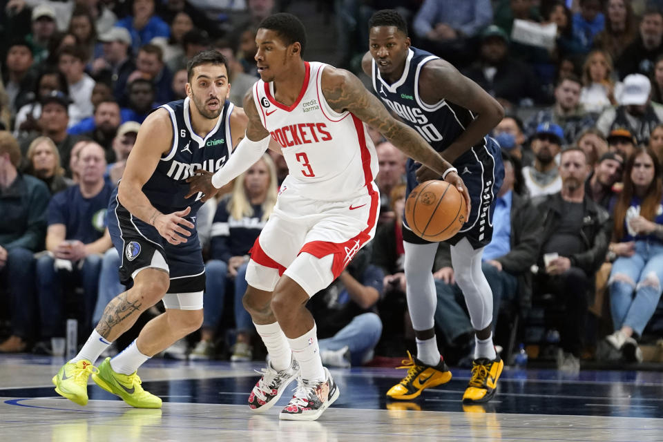 Houston Rockets guard Kevin Porter Jr. (3) dribbles is defended by Dallas Mavericks guard Facundo Campazzo, left, and forward Dorian Finney-Smith (10) during the first quarter of an NBA basketball game in Dallas, Wednesday, Nov. 16, 2022. (AP Photo/LM Otero)