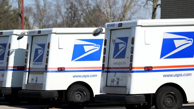 U.S. Postal Service trucks park outside a post office