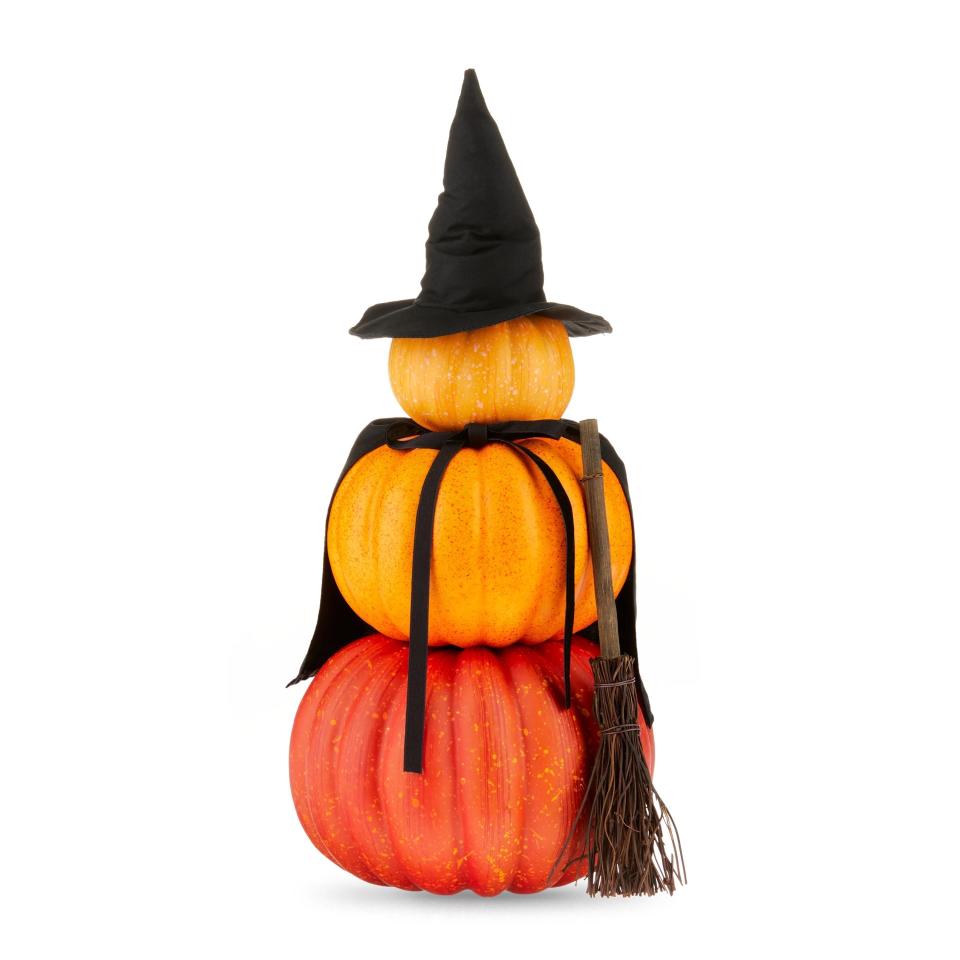 a triple stack of pumpkins with a witch's hat and broom