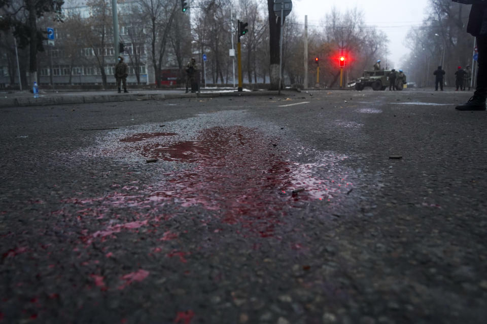 A blood is seen on the road as Kazakhstan soldiers patrol a street after clashes in Almaty, Kazakhstan, Thursday, Jan. 6, 2022. Kazakhstan's president authorized security forces on Friday to shoot to kill those participating in unrest, opening the door for a dramatic escalation in a crackdown on anti-government protests that have turned violent. The Central Asian nation this week experienced its worst street protests since gaining independence from the Soviet Union three decades ago, and dozens have been killed in the tumult.(Vladimir Tretyakov/NUR.KZ via AP)