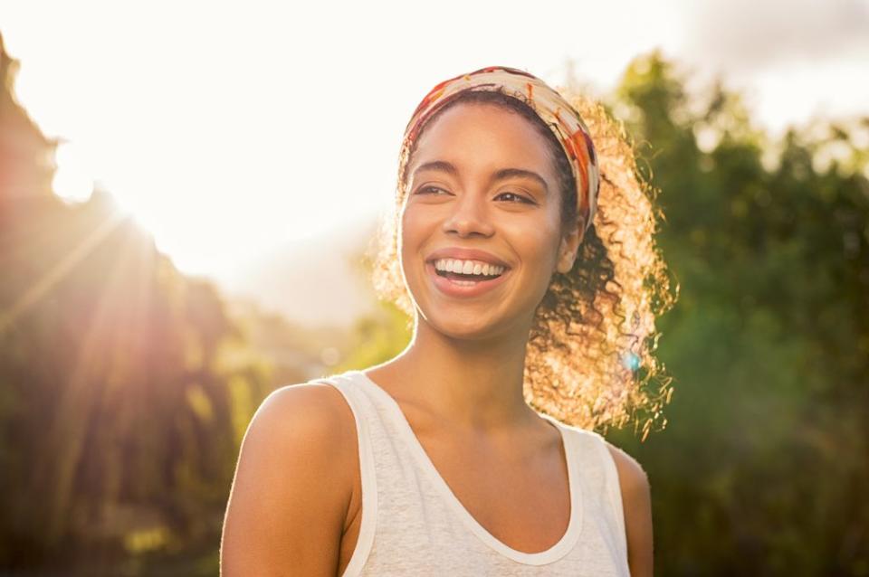 mujer con el pelo rizado sonriente y feliz