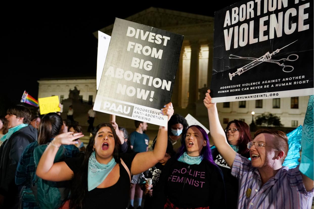 A crowd of people gather outside the Supreme Court, Monday night, May 2, 2022 in Washington. A draft opinion circulated among Supreme Court justices suggests that earlier this year a majority of them had thrown support behind overturning the 1973 case Roe v. Wade that legalized abortion nationwide, according to a report published Monday night in Politico.