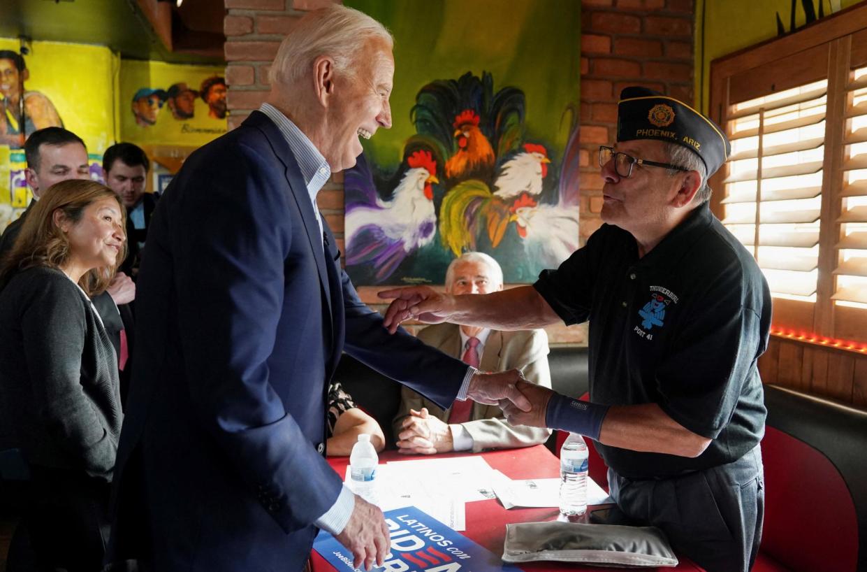 <span>Joe Biden greets a supporter during a campaign event at a Mexican restaurant in the Phoenix area of Arizona, on Tuesday.</span><span>Photograph: Kevin Lamarque/Reuters</span>